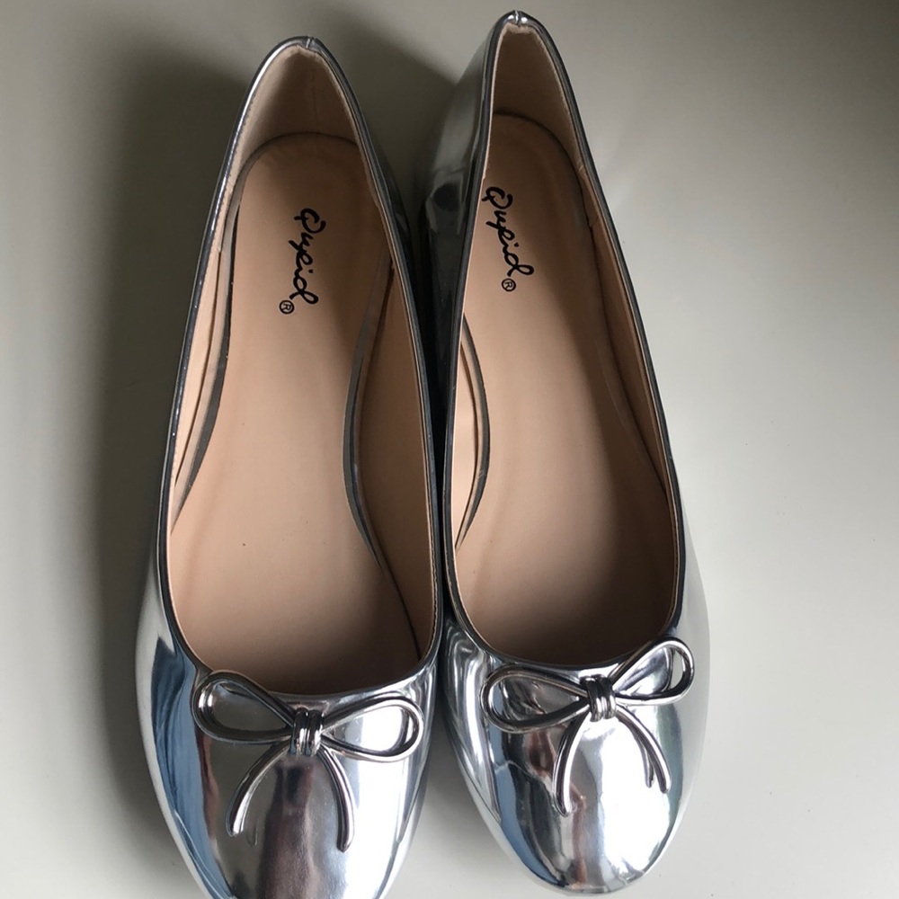 Silver flat shoes.